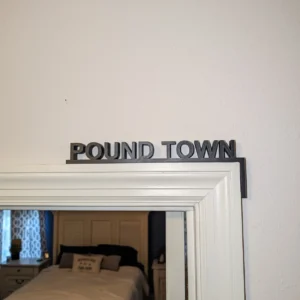 Pound Town 3D-printed bedroom sign mounted over a doorway