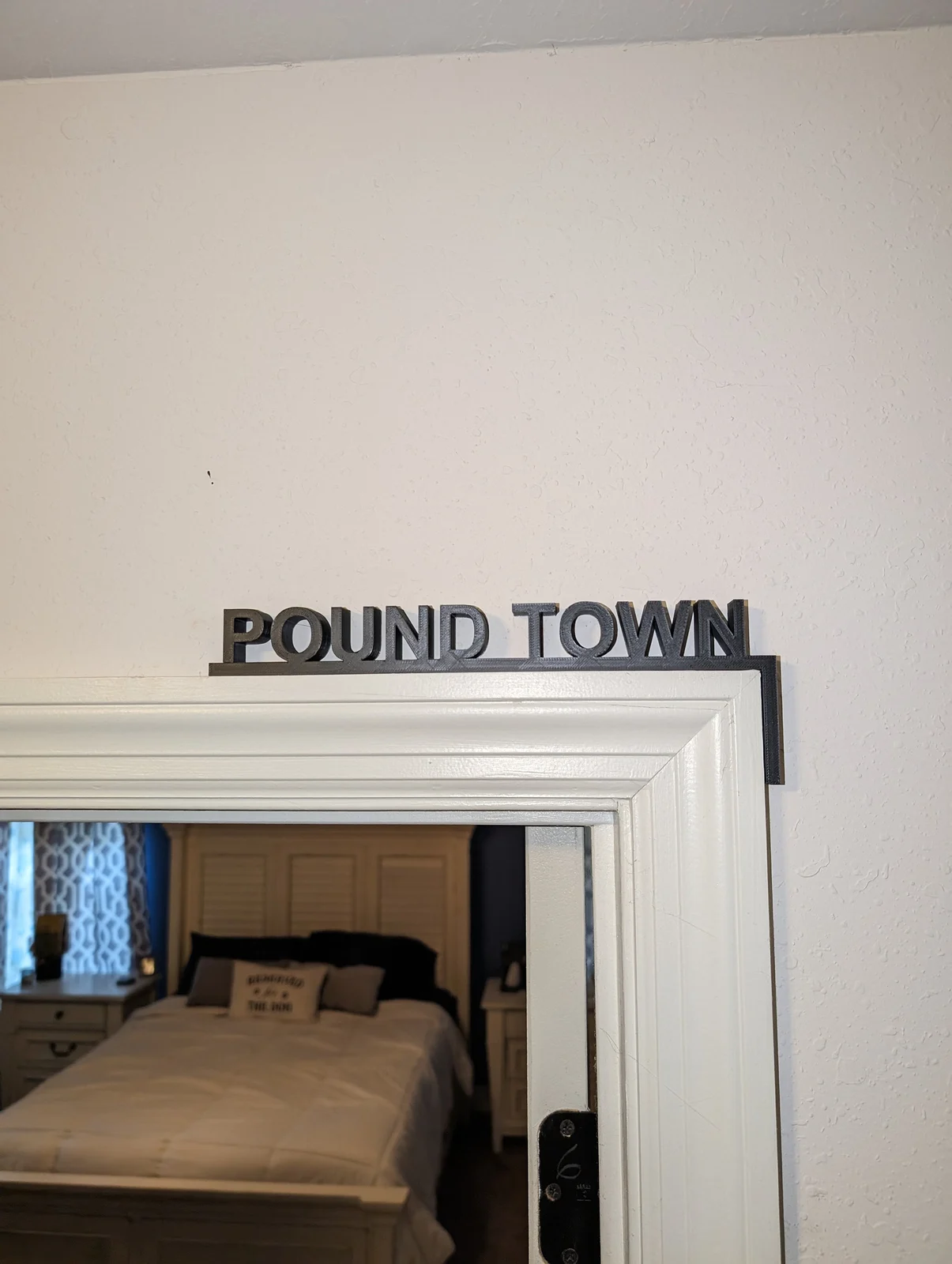 Pound Town 3D-printed bedroom sign mounted over a doorway